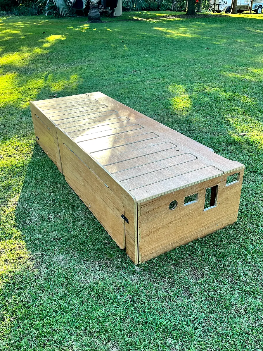 Comb bed stowed — solid timber top with two small vent cutouts