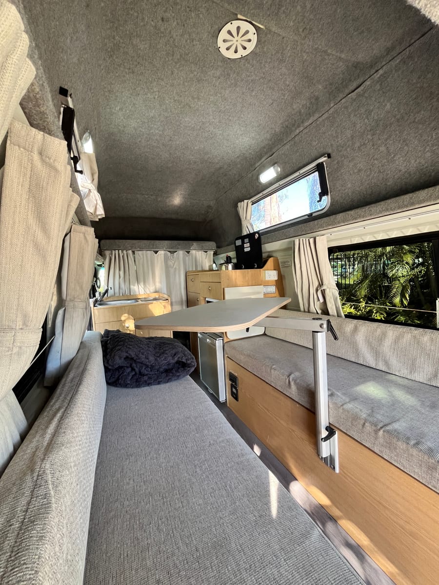 Hitop Hiace interior in day mode — dinette with table deployed
