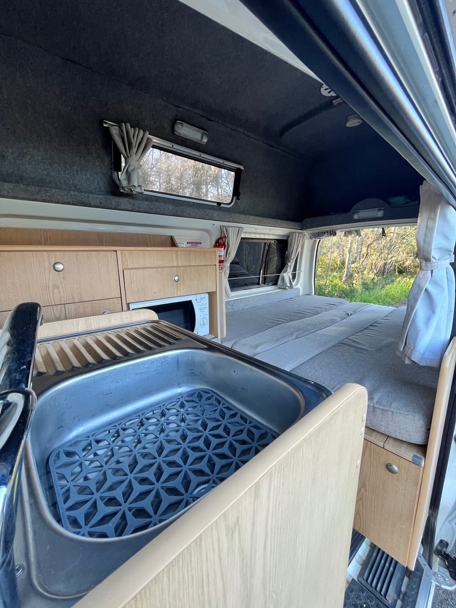 Hitop Hiace interior looking back to front — kitchen through to bed