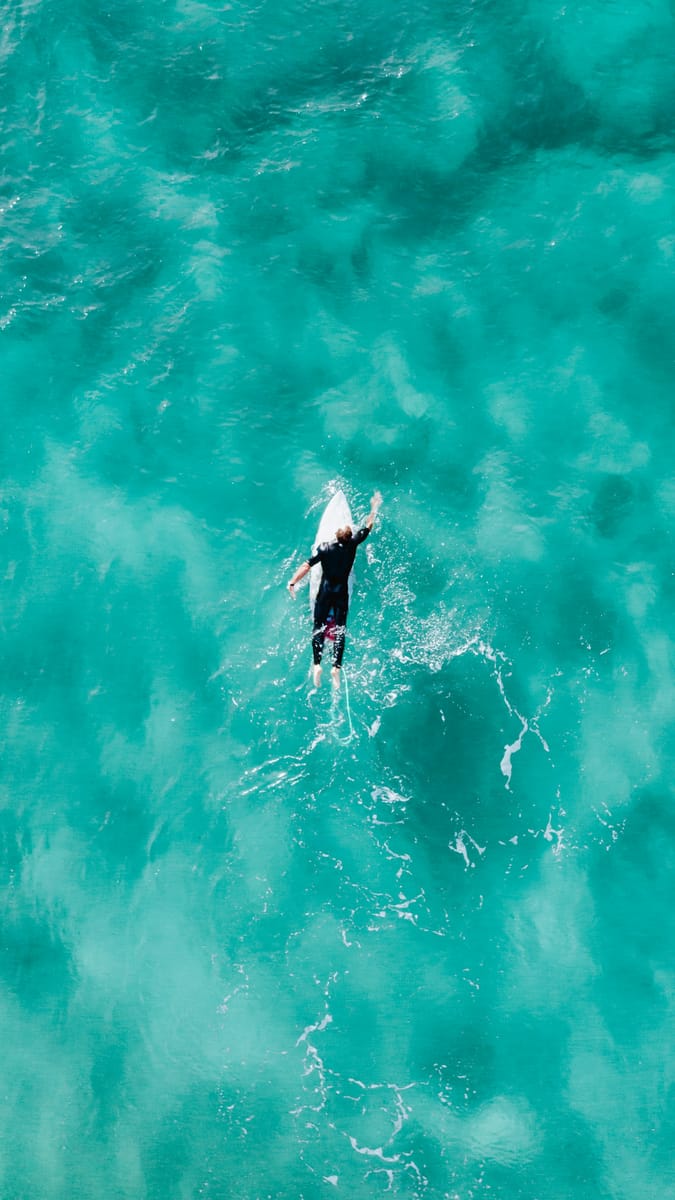 Surfer in a wetsuit walking out for a winter session